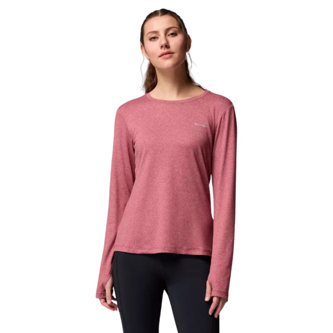 Une femme vêtue d'une chemise Columbia rouge rosé à manches longues et d'un legging noir se tient debout, de face, sur un fond blanc uni.