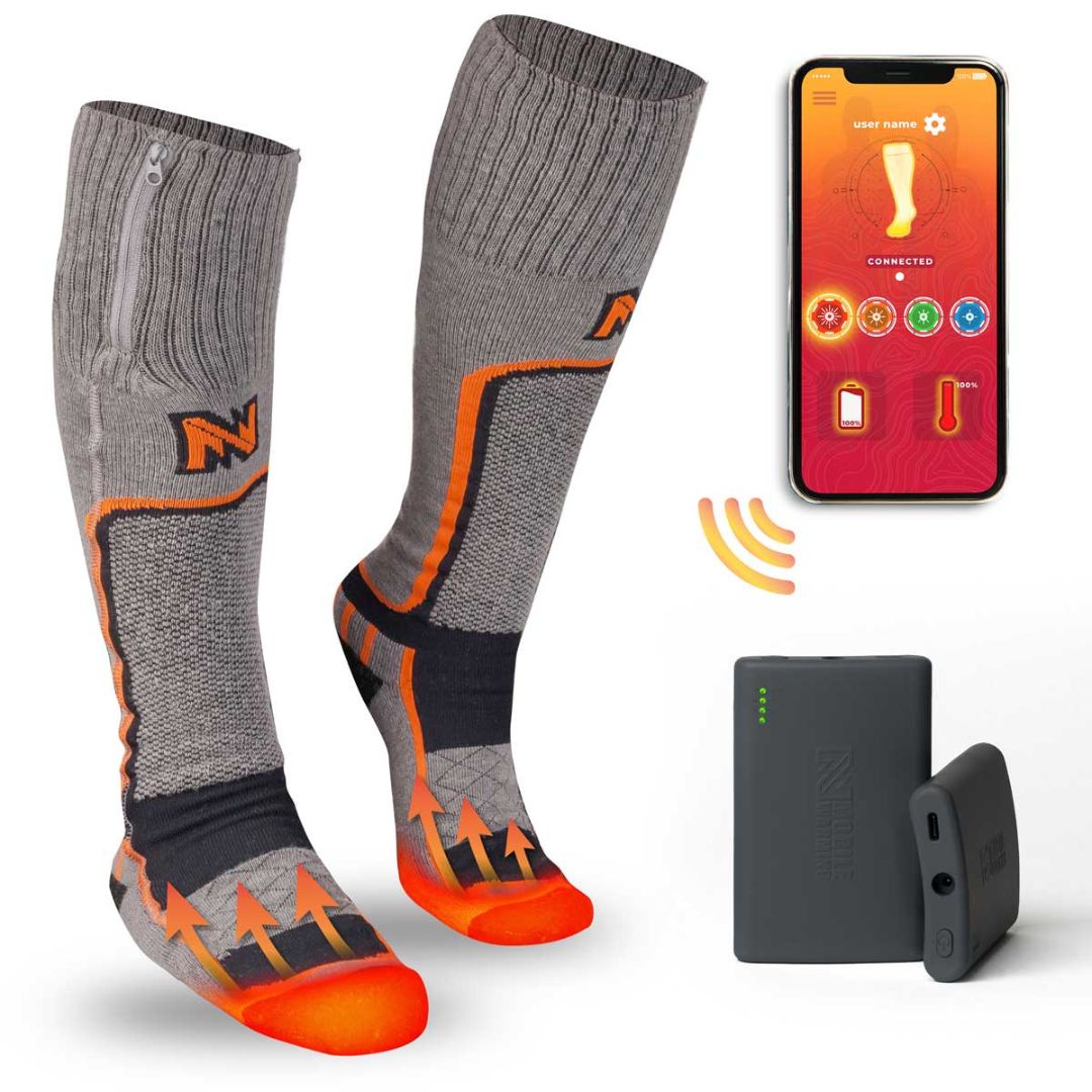 Les PRO MERINO HEATED SOCKS MEN'S, présentés en gris et orange avec une pochette à fermeture éclair, comportent des flèches orange pour indiquer les zones de chaleur. Deux packs de batteries noires et une application pour smartphone affichant les commandes sont également illustrés.