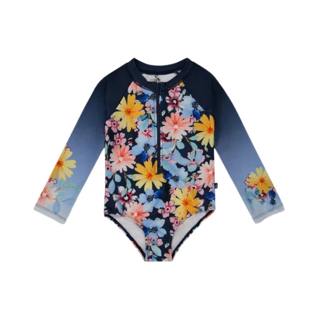 Maillot de bain une pièce anti-éruption à manches longues avec fermeture éclair sur le devant. Il présente un fond bleu dégradé et un motif floral vibrant composé de fleurs jaunes, roses et bleues.