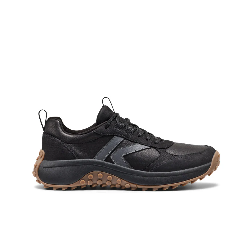 Le modèle KS86 LEA se caractérise par un design sportif noir, avec une semelle marron texturée, un laçage à l'avant et un motif en zigzag gris sur le côté, présenté ici vu de gauche sur fond blanc.