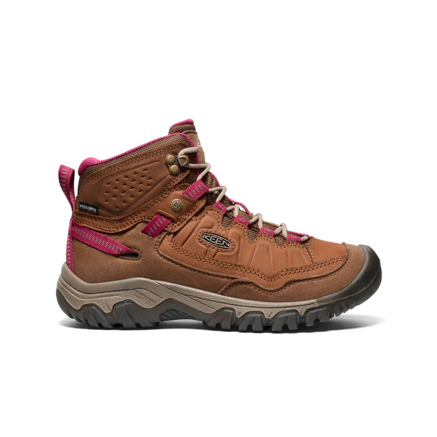 La TARGHEE IV MID WP est une chaussure de randonnée marron avec une semelle épaisse et robuste, des accents roses et un design à lacets. Elle présente des détails cousus, des œillets métalliques et un petit logo KEEN sur le côté.