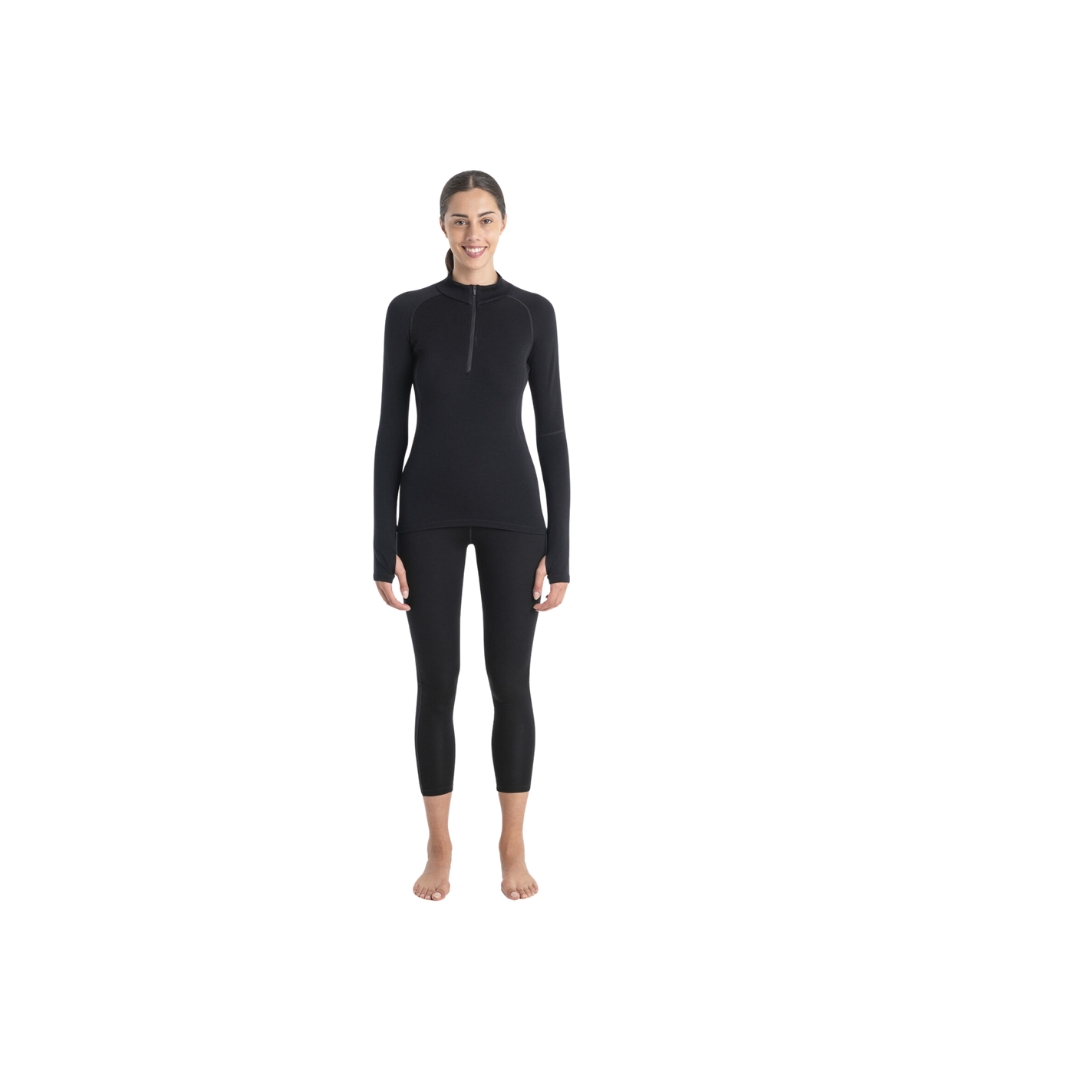 HAUT COUCHE DE BASE ICEBREAKER À MANCHE LONGUE AVEC DEMI GLISSIÈRE MÉRINOFINE™ 300 POUR FEMME de couloir noir porter par une femme vue a pleine grandeur de la tête au pied