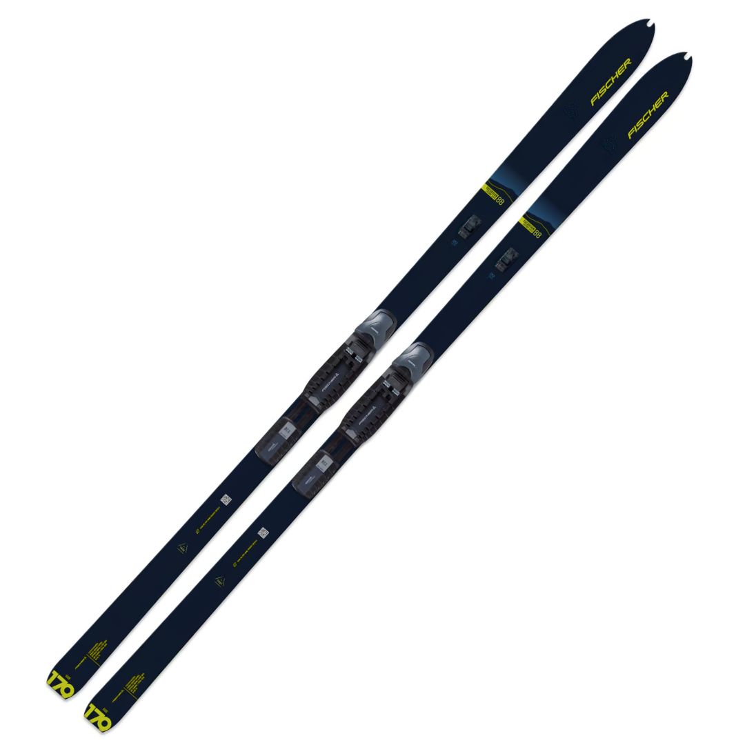 Une paire de skis de fond Fischer Excursion 88 Crown/Dual-Skin Xtralite avec fixations, bleu foncé avec des accents jaunes et la marque sur les pointes et les queues, présentés sur un fond blanc.