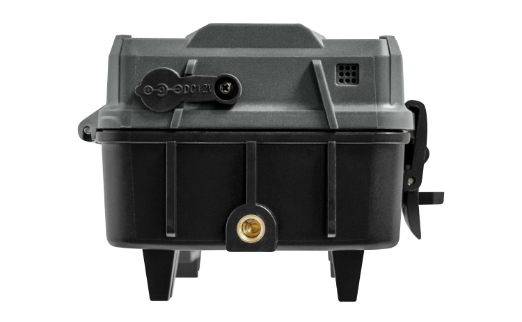 Gros plan d'un appareil électronique compact, noir et gris, doté d'un port de connexion à gauche et de petites ouvertures à droite. L'appareil est doté d'une base robuste avec deux pieds et semble conçu pour une utilisation industrielle ou technique.