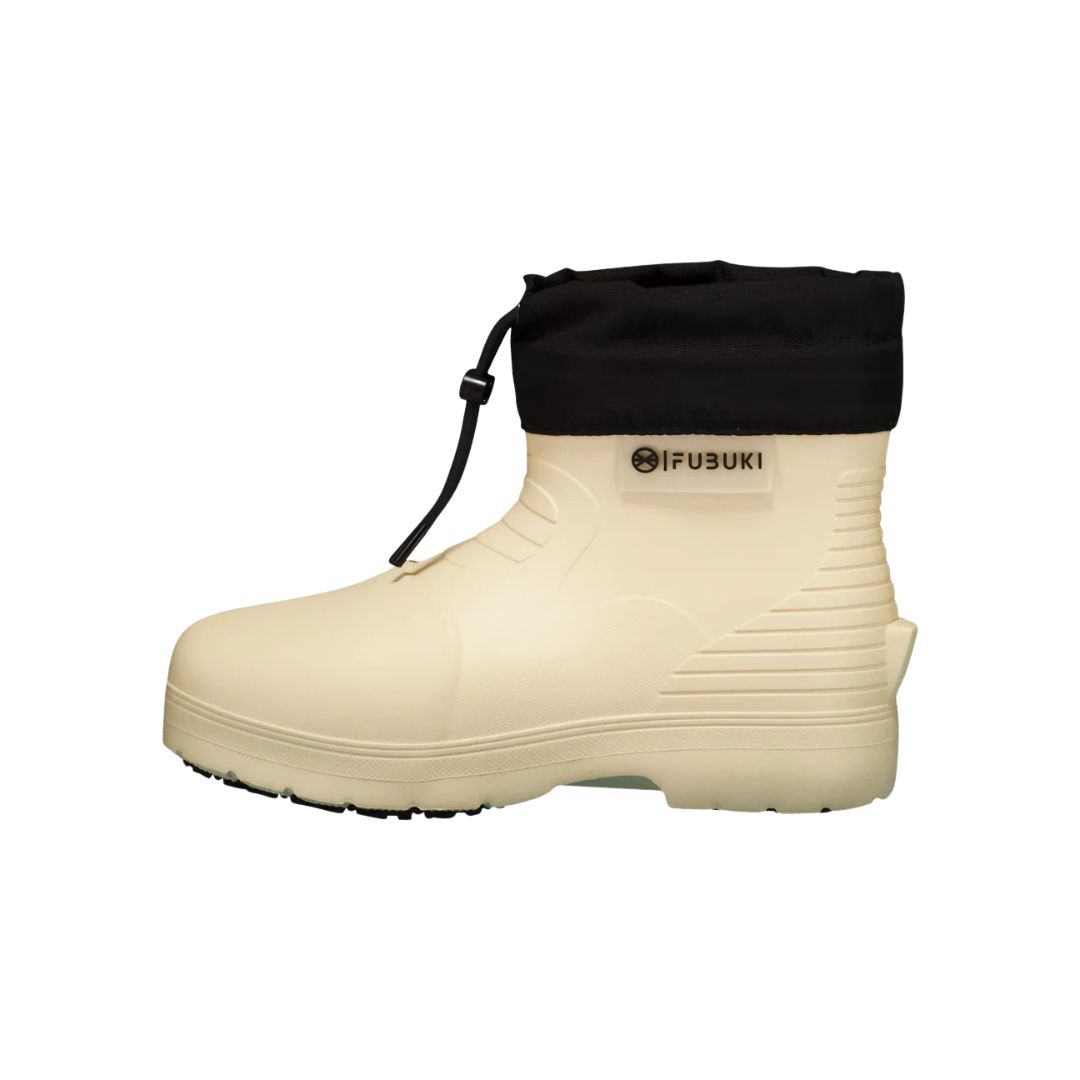 Une botte beige avec une tige noire et une fermeture à cordon. La botte a une conception robuste avec une texture côtelée près du talon et une semelle épaisse. Un logo avec le texte "FUBUKI" est visible sur le côté.
