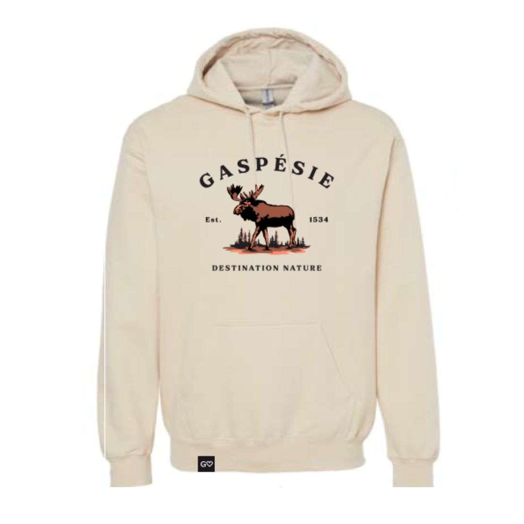 Le HOODIE BRODERIE ORIGNAL 2.0 est un sweat à capuche beige avec un graphique d'orignal, des arbres et les textes "GASPÉSIE", "Est. 1534" et "DESTINATION NATURE" sur le devant.