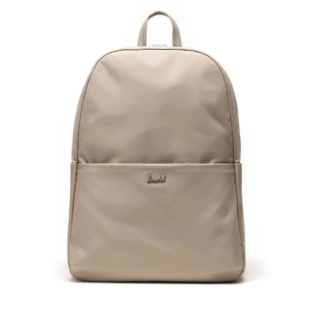 Le SAC-À-DOS HERSCHEL BEATRIX 20 L est un sac à dos beige au design simple et minimaliste, doté d'une poche avant, d'une petite poignée en boucle sur le dessus et du nom de la marque brodé sur la poche avant.