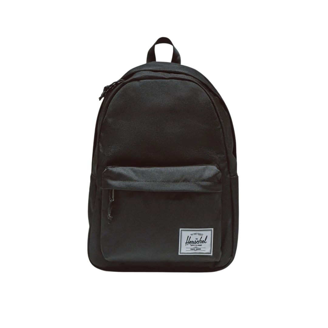 Un sac à dos noir doté d'une poche avant à fermeture éclair et d'un petit logo blanc cousu près du bas, photographié sur un fond blanc uni.