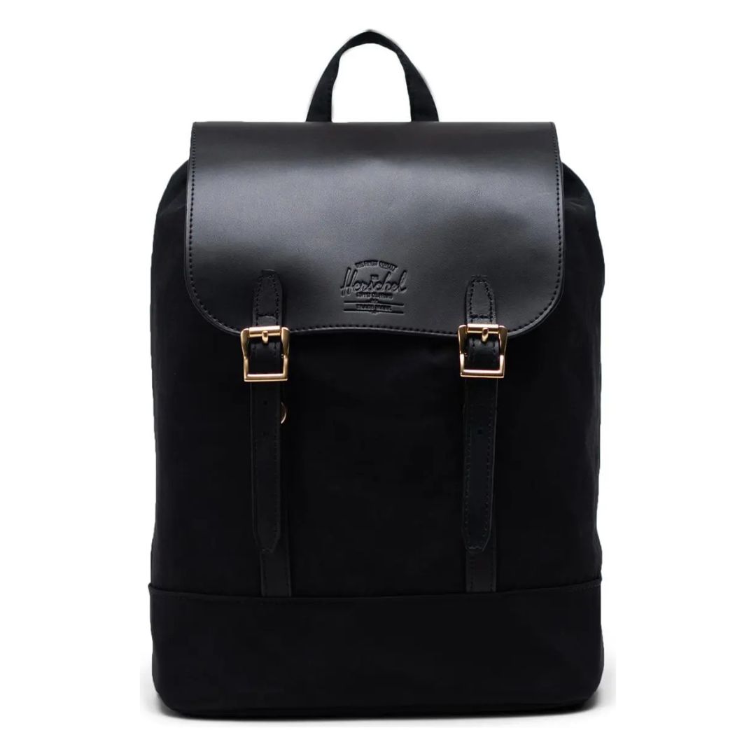 SAC À DOS COMPACT HERSCHEL ORION RETREAT, au design noir épuré, doté d'un rabat en cuir, de deux boucles métalliques, d'une poignée sur le dessus et d'un logo discret sur le rabat. Son style est minimaliste et moderne.