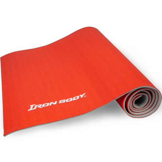 Gros plan d'un tapis de yoga rouge partiellement enroulé sur lequel est imprimé en blanc l'inscription « Iron Body ». Le tapis est présenté sur un fond blanc.