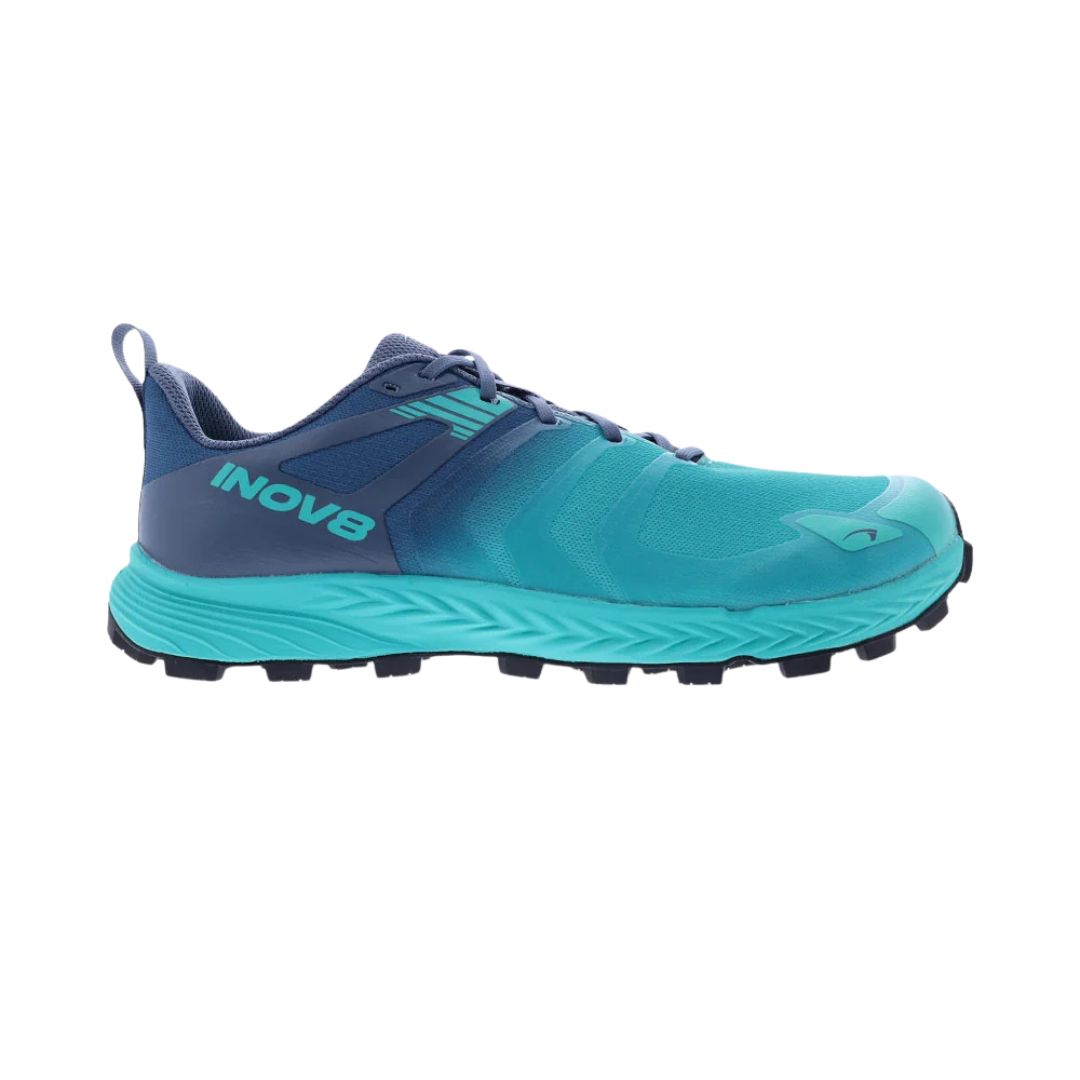 La SOULIER DE COURSE SUR SENTIER INOV8 TAILTALON SPEED POUR FEMME est une chaussure de trail bleu et sarcelle pour femme avec "INOV8" sur le côté, une semelle extérieure noire robuste et une fermeture à lacets, présentée de profil gauche sur fond blanc.
