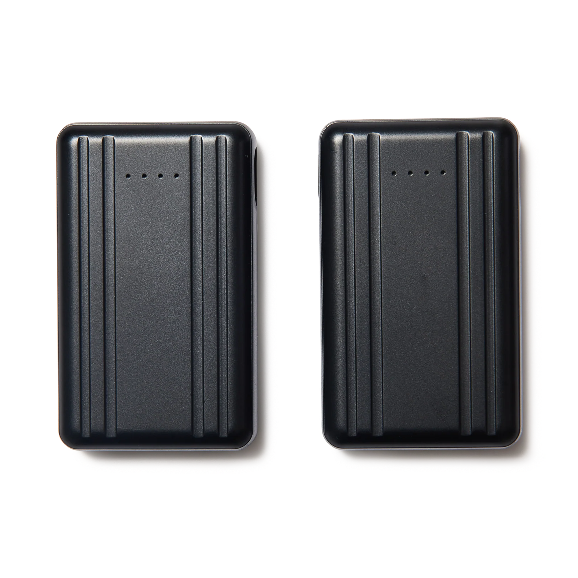 Deux appareils rectangulaires noirs présentant des designs épurés et rainurés et une rangée de petits voyants lumineux sur chacun, positionnés côte à côte sur un fond blanc.
