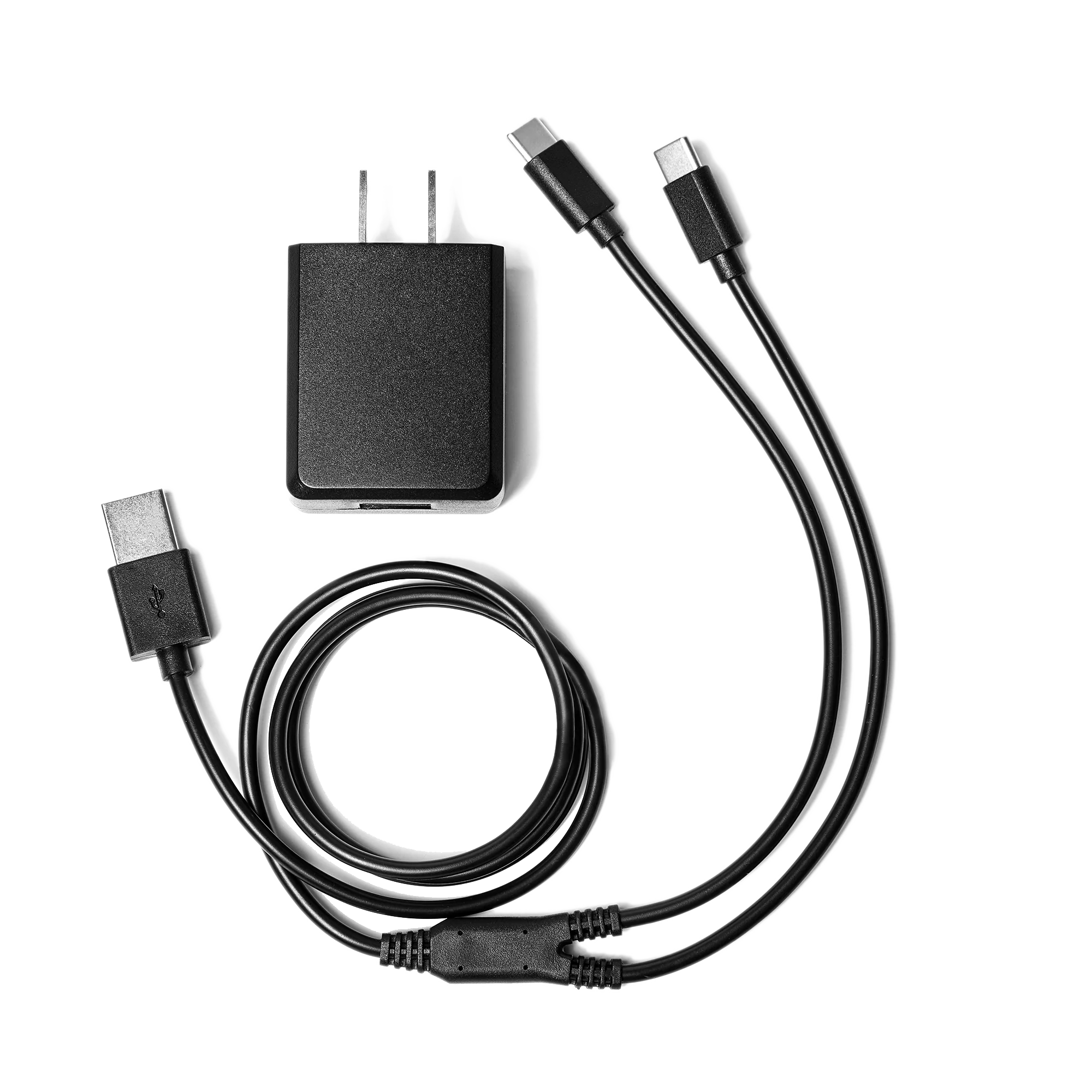 Un chargeur mural noir avec deux ports USB-C est affiché à côté de deux câbles USB-C. L'un est spiralé et l'autre est droit avec des connecteurs aux deux extrémités. Tous les éléments sont disposés sur un fond blanc.
