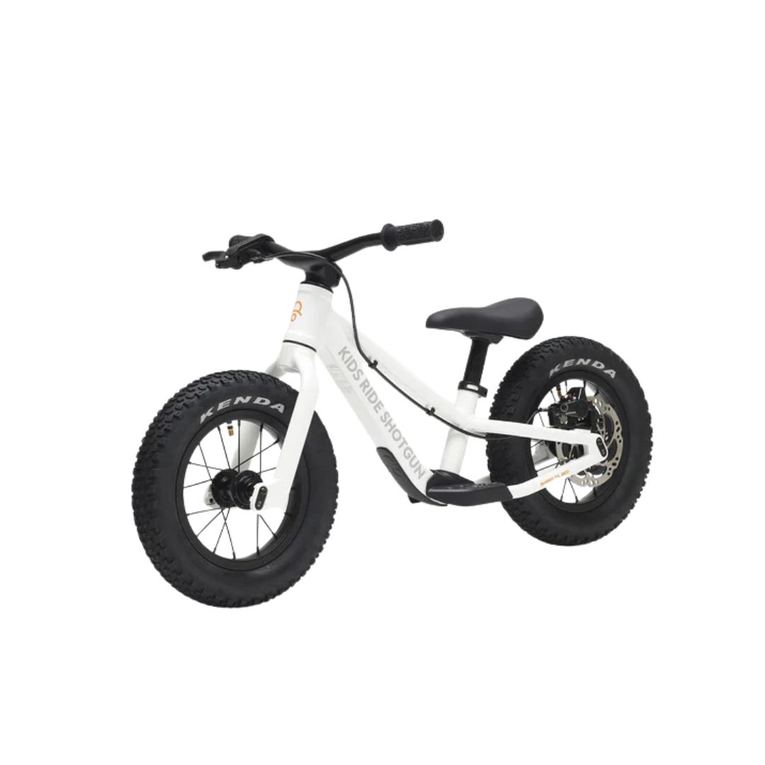 Le DIRT HERO PUSH BIKE 12" est un vélo d'équilibre blanc pour enfants, équipé d'épais pneus Kenda noirs, d'une selle noire et de la mention "KIDS RIDE SHOTGUN" sur le cadre, sur un fond blanc uni.