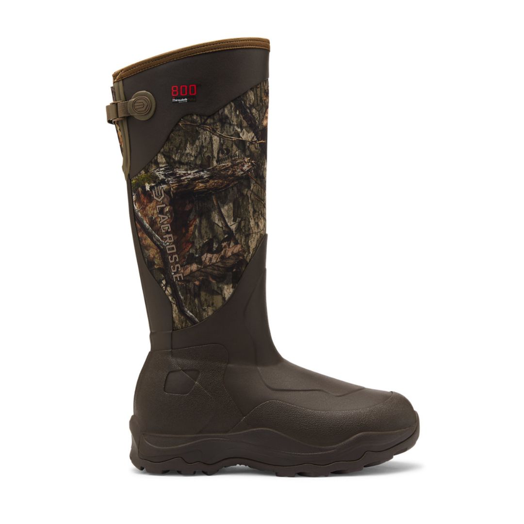 Une botte de chasse haute et imperméable, ornée d'un motif camouflage sur la partie supérieure, d'une partie inférieure marron et d'une semelle robuste. Elle est dotée de brides réglables et des logos « 800 » et « LACROSSE » sur le côté.