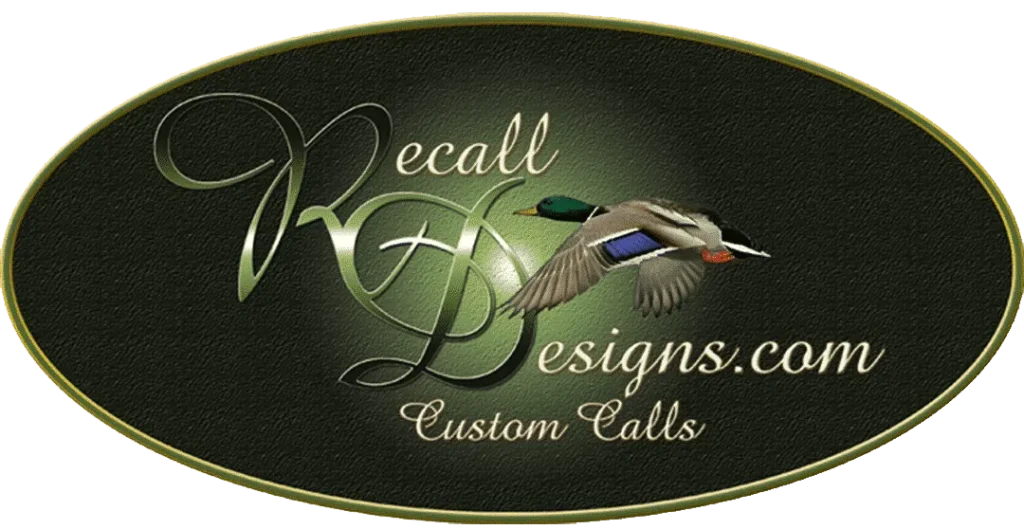 Logo pour RecallDesigns.com Custom Calls comprenant un texte élégant en script et un canard colvert en vol sur un fond ovale foncé avec une fine bordure dorée.
