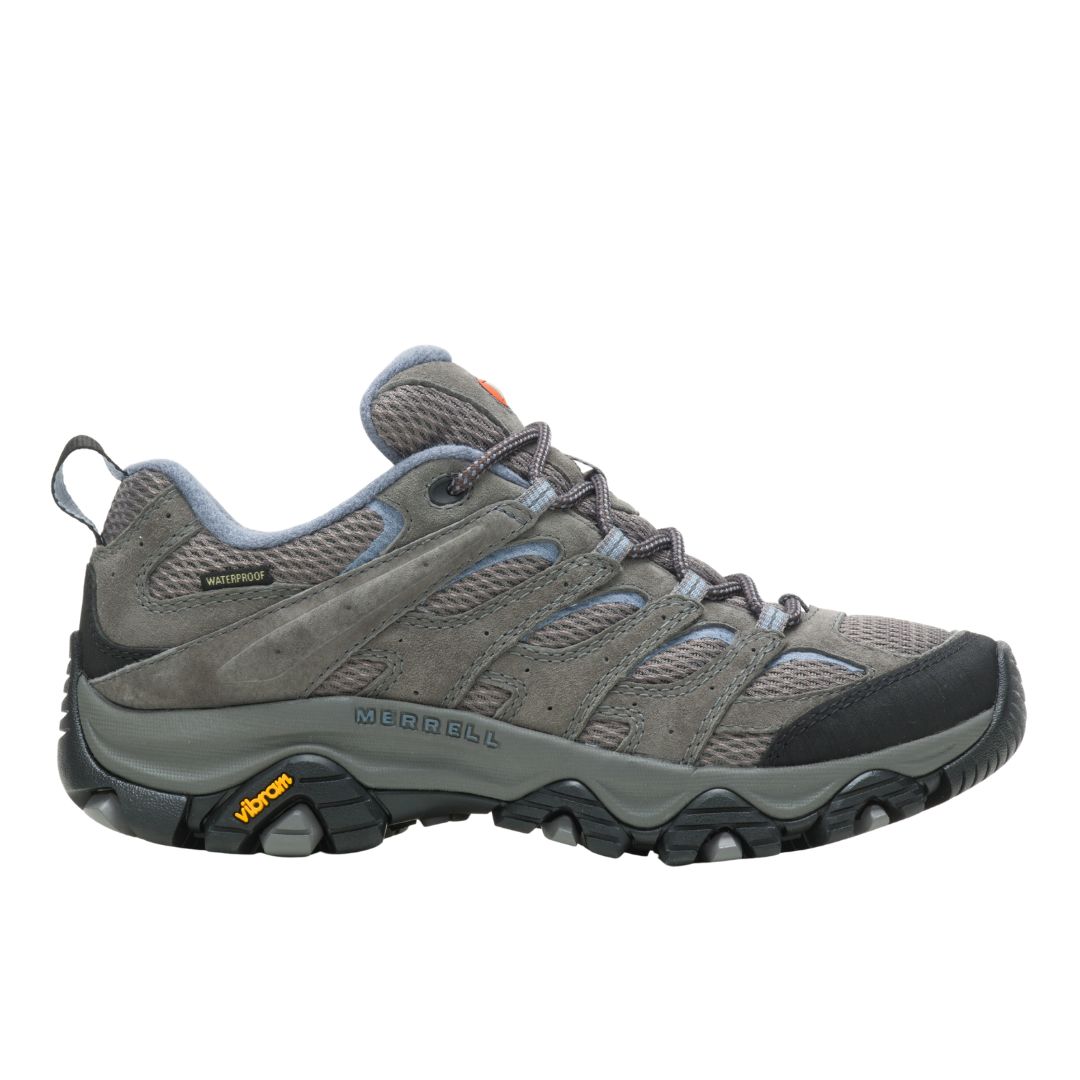 La chaussure de randonnée imperméable Merrell Moab 3 (LARGE) pour femme, de couleur grise, est dotée d'une semelle crantée Vibram avec un logo jaune, d'une tige en mesh et en daim, d'un bout renforcé noir et est représentée de profil sur fond blanc.