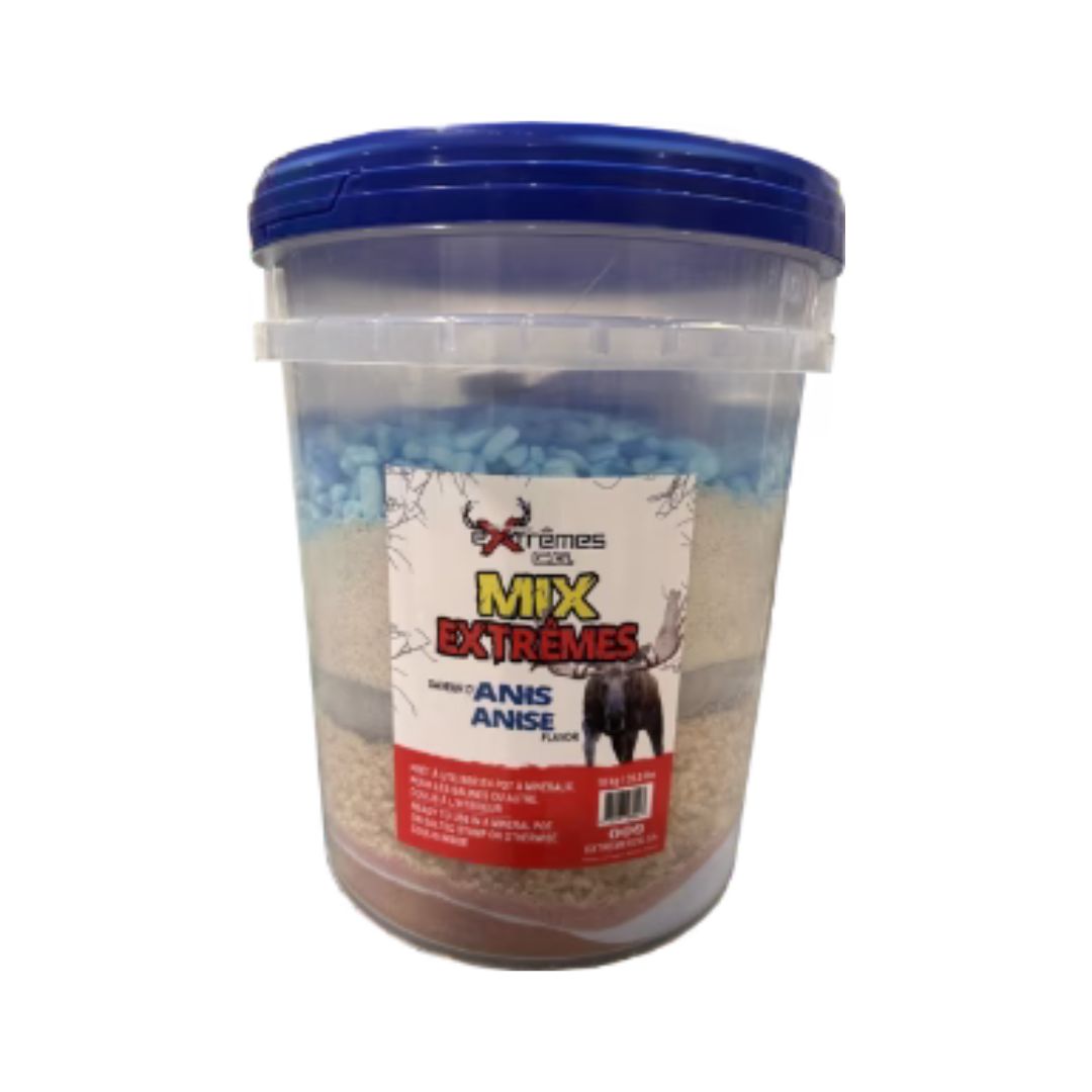 Un récipient en plastique transparent avec un couvercle bleu étiqueté "CHAUDIÈRE DE MINÉRAUX EXTRÊMES C.G. MIX EXTRÊMES ANIS POUR ORIGNAL 15KG", montrant à l'intérieur un assortiment de grains mélangés ou d'appâts. L'étiquette présente des images d'animaux et un texte en espagnol et en anglais.