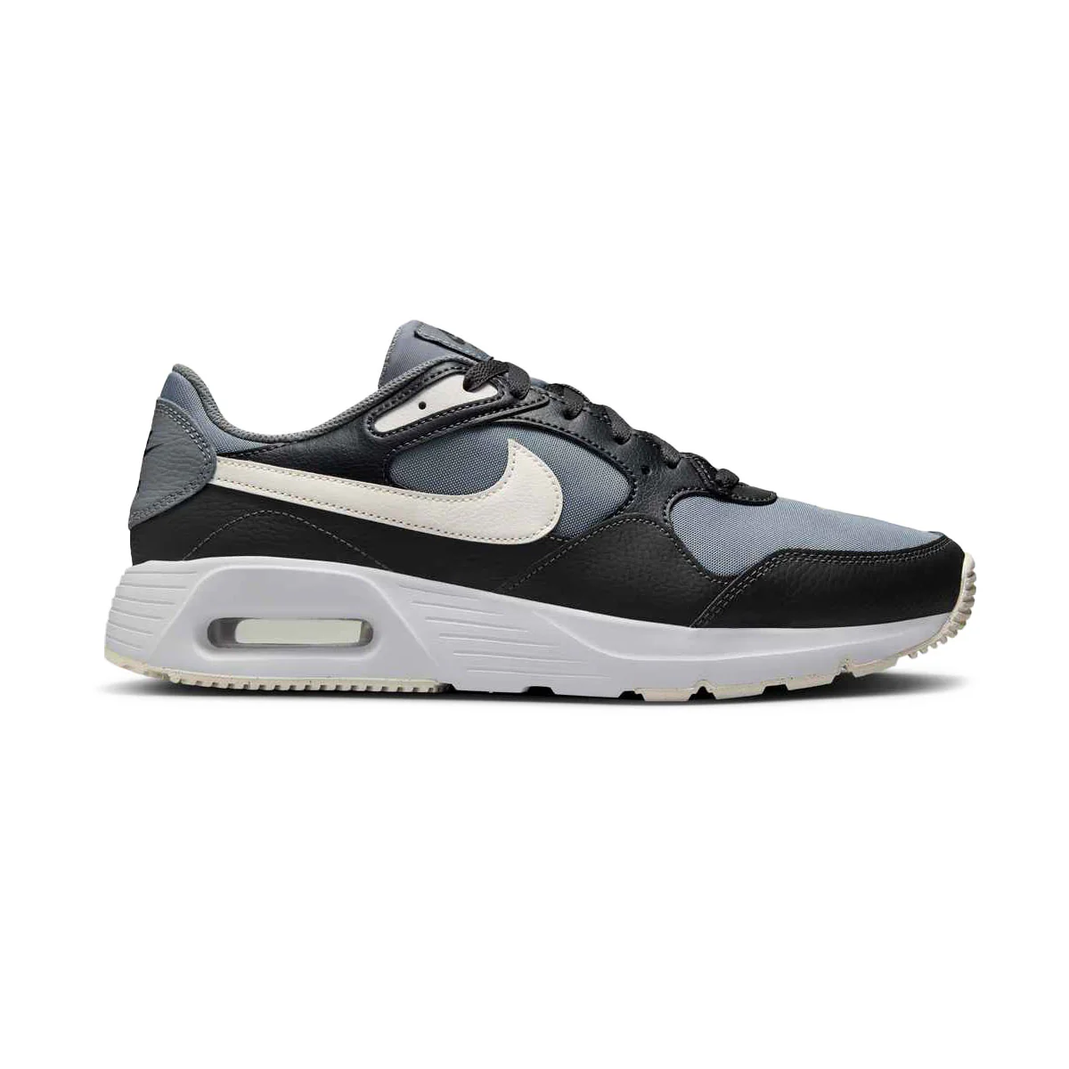 Chaussure de sport Nike Air Max en noir, gris et blanc, avec un logo swoosh blanc, des empiècements en maille et en cuir, un coussin d'air visible dans la semelle et un design athlétique à taille basse vu de profil.