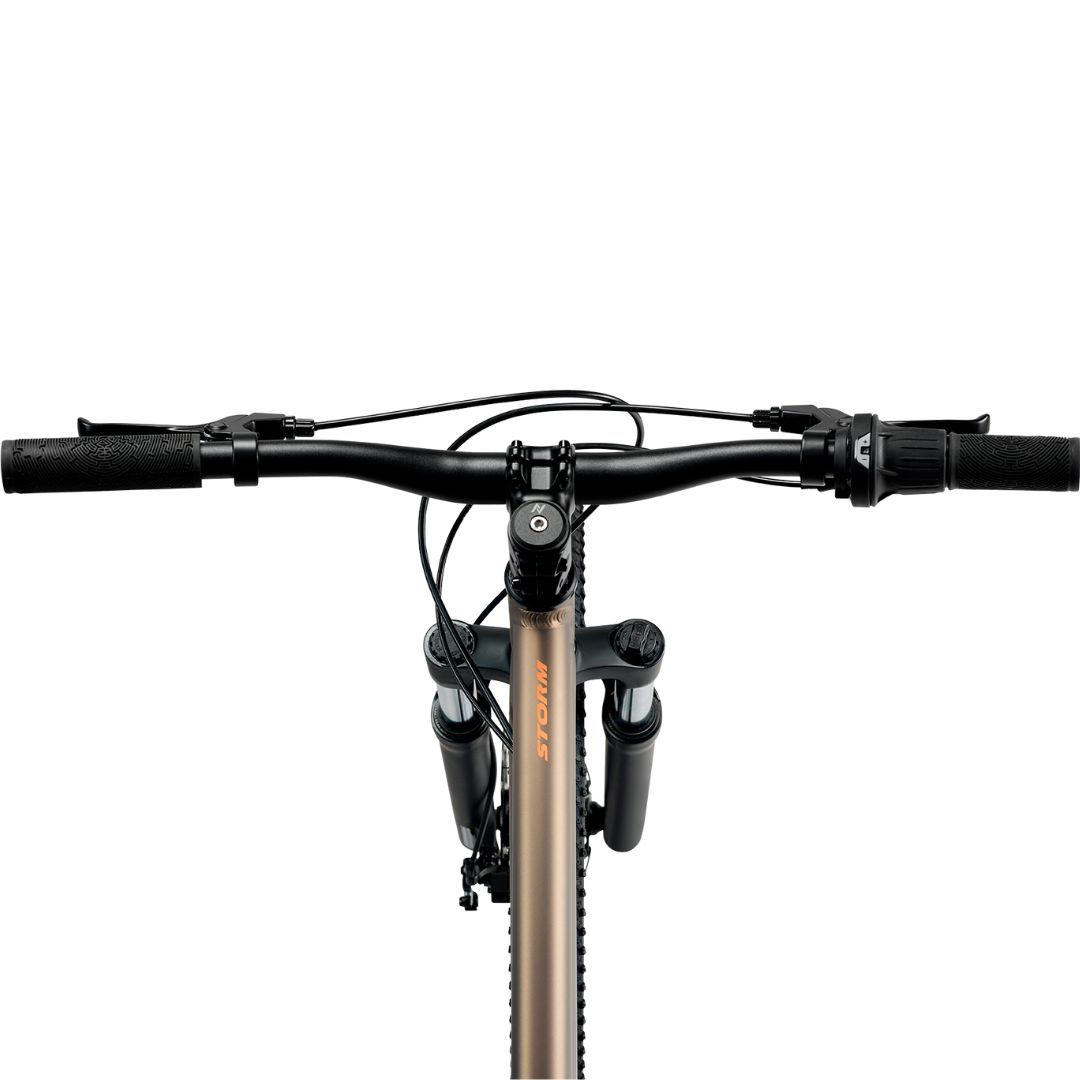 Vue de face du guidon d'un vélo, montrant les poignées, les leviers de frein, les leviers de vitesses et les câbles noirs, avec la fourche avant et le pneu partiellement visibles en dessous. Le fond est blanc uni.