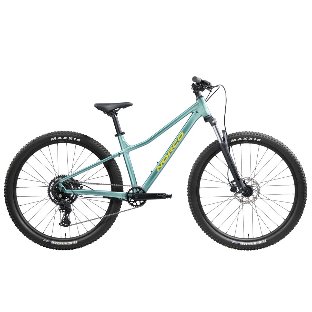 Un vélo de montagne Norco STORM bleu clair avec suspension avant, pneus Maxxis épais, freins à disque et tube supérieur incliné est montré en vue latérale sur un fond blanc.