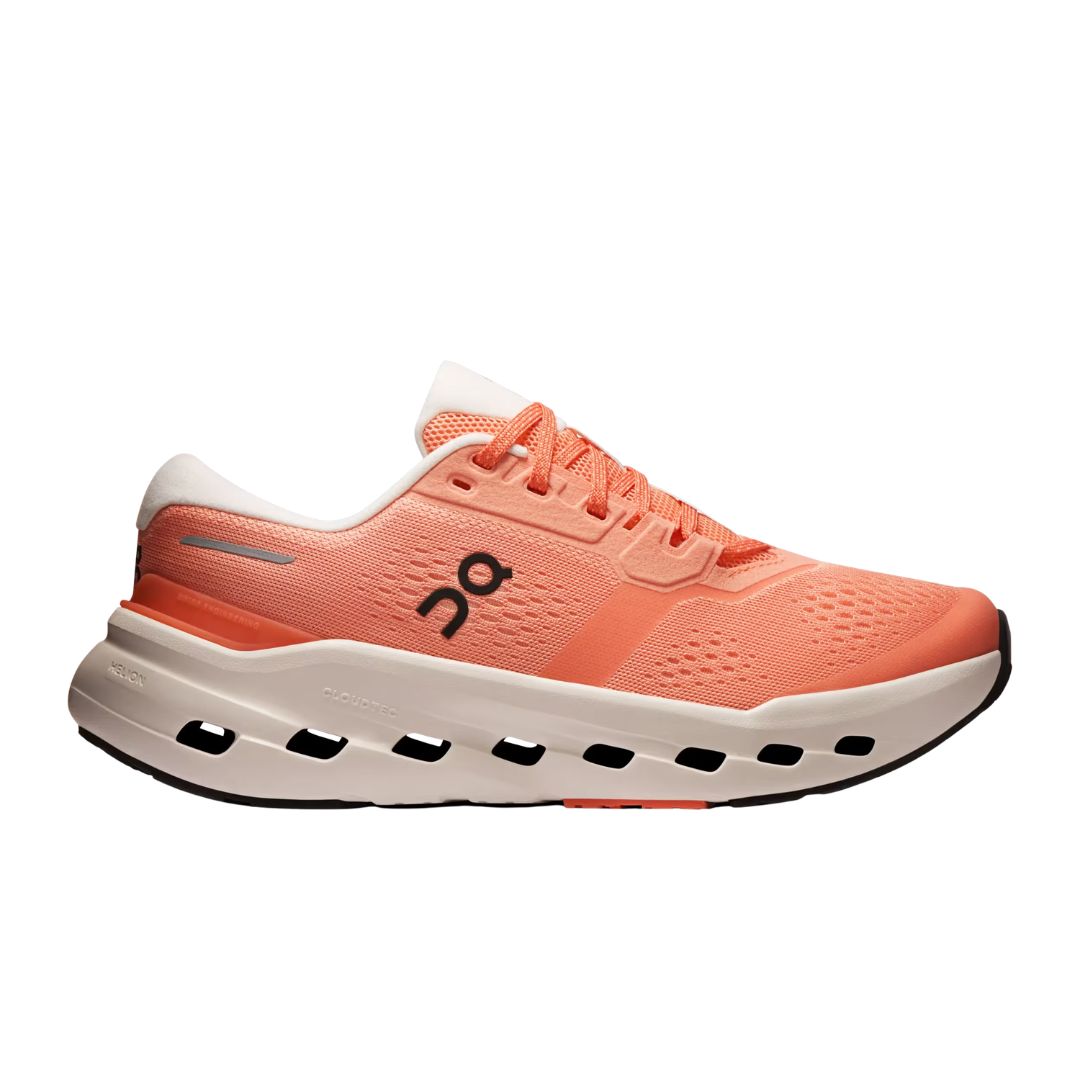 La CLOUDRUNNER 3 W est une chaussure de course corail-orange avec des détails en mesh, une semelle amortissante blanche avec des découpes, un talon blanc, une fermeture à lacets et un logo ON noir sur le côté.