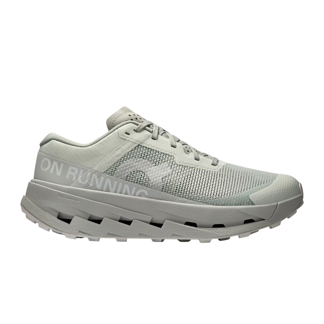 La CLOUDULTRA 3 W est une chaussure de course gris clair avec une tige en mesh, une semelle épaisse et amortie, un design à lacets et une semelle extérieure texturée pour l'adhérence. La mention "ON RUNNING" est imprimée sur le côté.