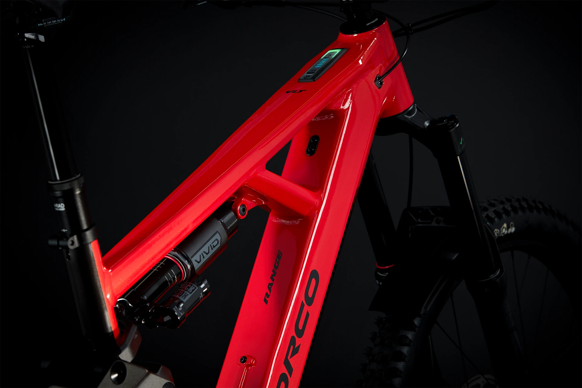 Gros plan d’un cadre de vélo de montagne rouge, mettant en valeur le système de suspension arrière et le logo Norco, avec un fond sombre soulignant le design élégant et moderne du vélo.