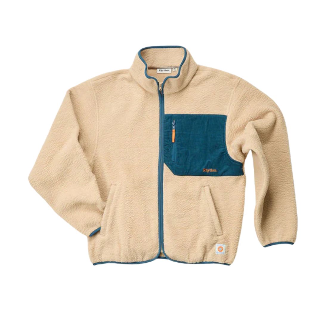 La veste CHANDAIL EN LAINE POLAIRE AVEC ZIP RHYTHM TRAIL POUR HOMME est une veste en polaire beige avec un devant zippé bleu, des bordures bleues, une grande poche poitrine bleue avec fermeture éclair, des poches latérales et un patch logo près de l'ourlet.