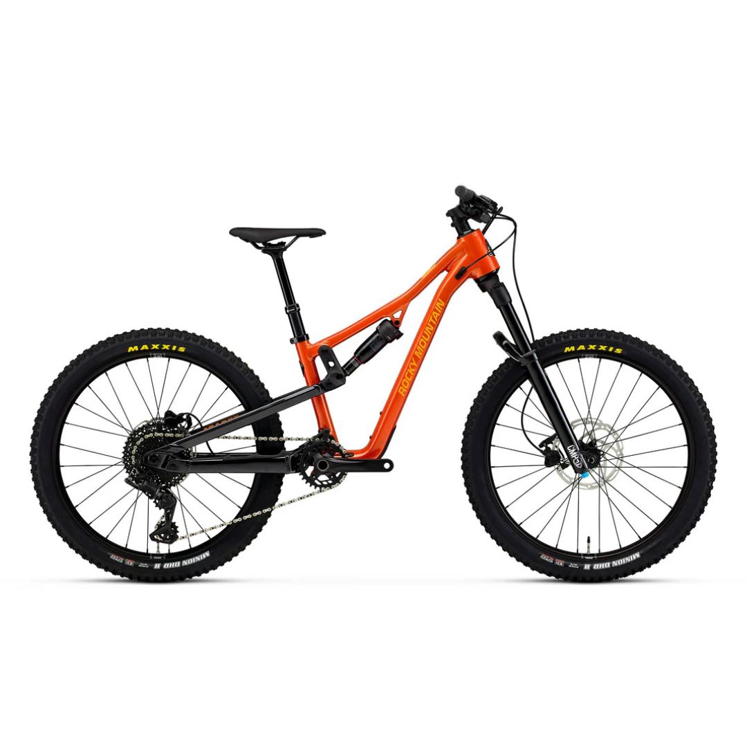 Le VÉLO DE MONTAGNE ROCKY MOUNTAIN REAPER 24 POUR JUNIOR est un VTT à suspension totale avec un cadre orange vif, une selle et un guidon noirs et des pneus Maxxis. Présenté de profil sur fond blanc, il est équipé de freins à disque.