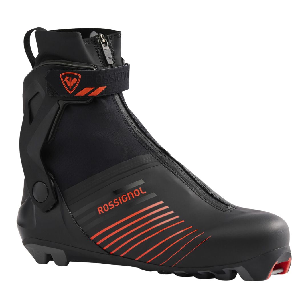 La BOTTE DE SKI DE FOND ROSSIGNOL X-11 SKATE est une chaussure de ski nordique noire avec des accents rouges, une housse zippée, une bande Velcro à la cheville et une semelle robuste, conçue pour le ski de fond.