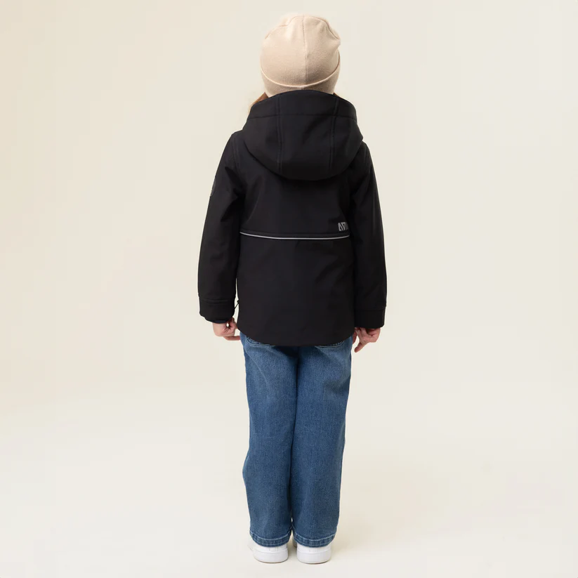 Vue de dos d'un enfant portant un bonnet beige, une veste à capuche noire et un jean bleu. L'arrière-plan est un mur blanc cassé uni.