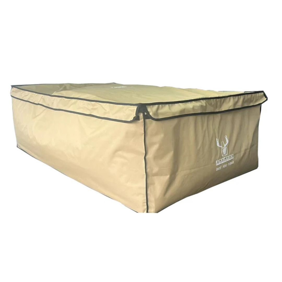 Un grand sac de rangement rectangulaire de couleur beige avec un couvercle à fermeture éclair et des bordures foncées. Le sac comporte un logo et un texte blancs sur le côté. La surface semble durable et convient à une utilisation en extérieur ou en voyage.