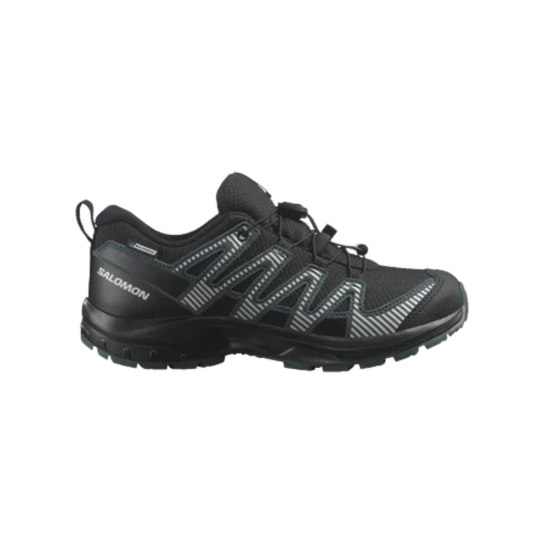 Chaussure de sport noire et verte avec motifs en zigzag sur le côté et semelle robuste, adaptée au trail. Le logo de la marque est visible près du talon. La chaussure présente une conception à lacets pour un ajustement sûr.