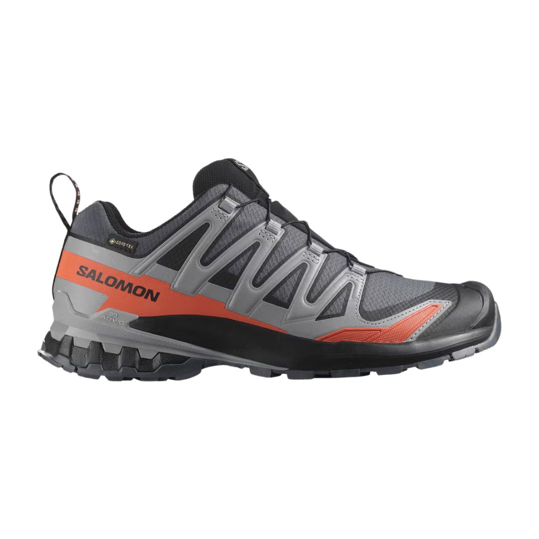 La XA PRO 3D V9 WIDE GTX est une chaussure de trail running Salomon grise et noire avec des accents orange, une semelle robuste, une tige en mesh respirante, un embout robuste et une conception Gore-Tex imperméable pour les aventures en plein air.