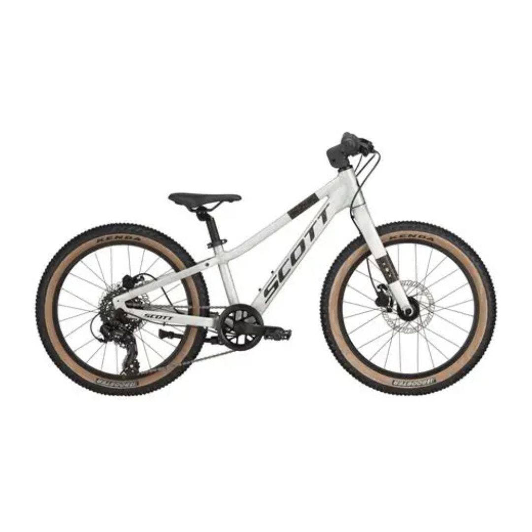 Le VÉLO JUNIOR SCOTT SCALE 200 est un VTT blanc avec des pneus épais aux flancs tan, un guidon noir et une selle noire. Équipé de freins à disque, il est conçu pour le tout-terrain ou le trail.