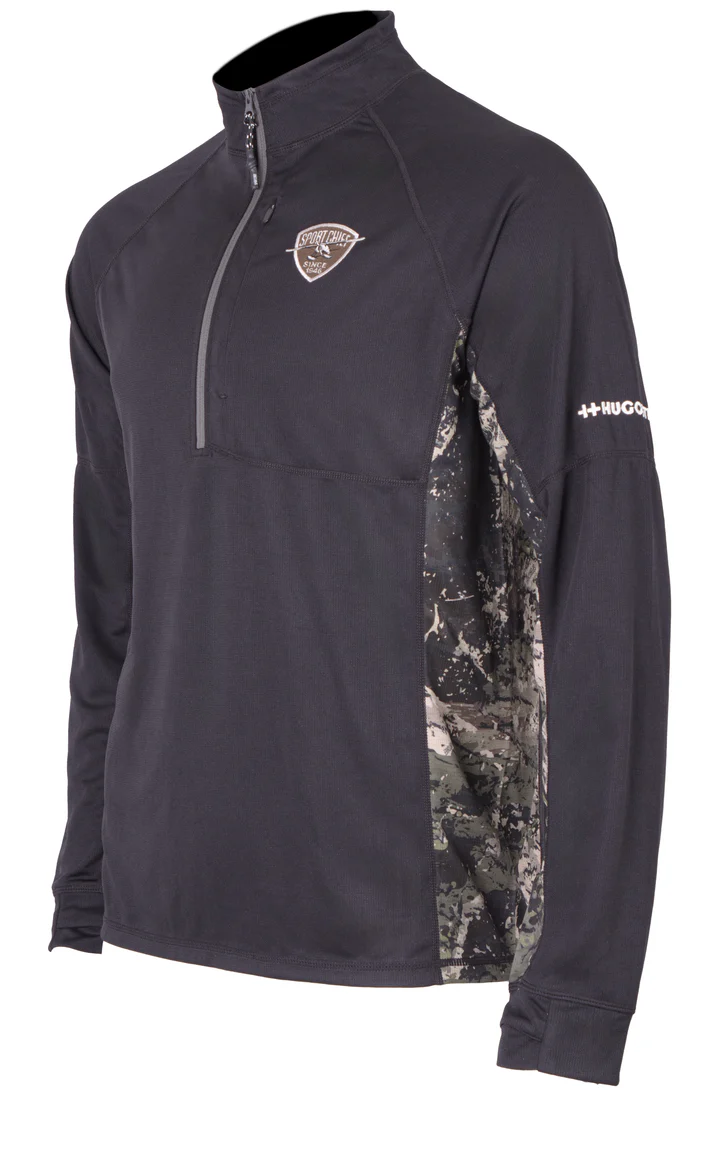 Chemise noire à manches longues avec fermeture éclair quart de tour et empiècements latéraux à motif camouflage, ainsi qu'un petit logo sur la poitrine représentant un bouclier. La manche droite porte le logo "HUKGEAR".