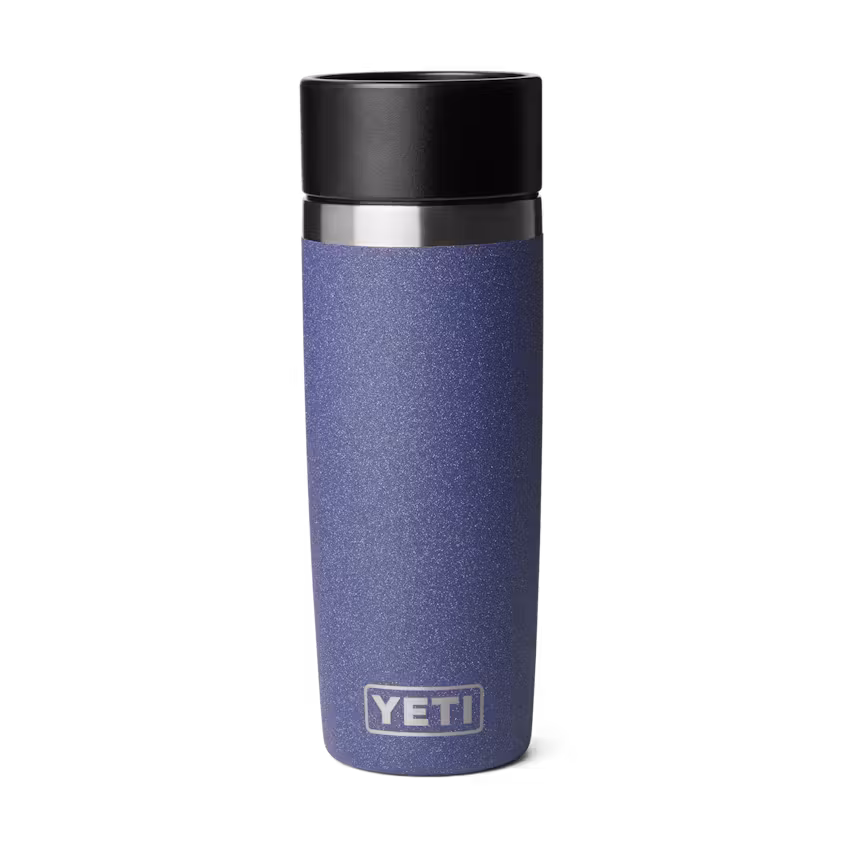 Un mug de voyage Yeti bleu avec un couvercle noir est représenté debout sur un fond blanc uni. Le logo Yeti apparaît près du bas de la tasse.