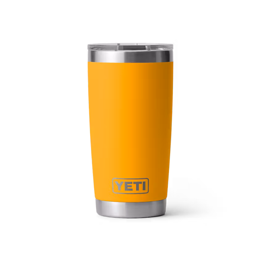 Un gobelet YETI jaune avec un couvercle et une base argentés est représenté debout sur un fond blanc uni. Le logo YETI est bien visible sur la partie inférieure de l'avant du gobelet.