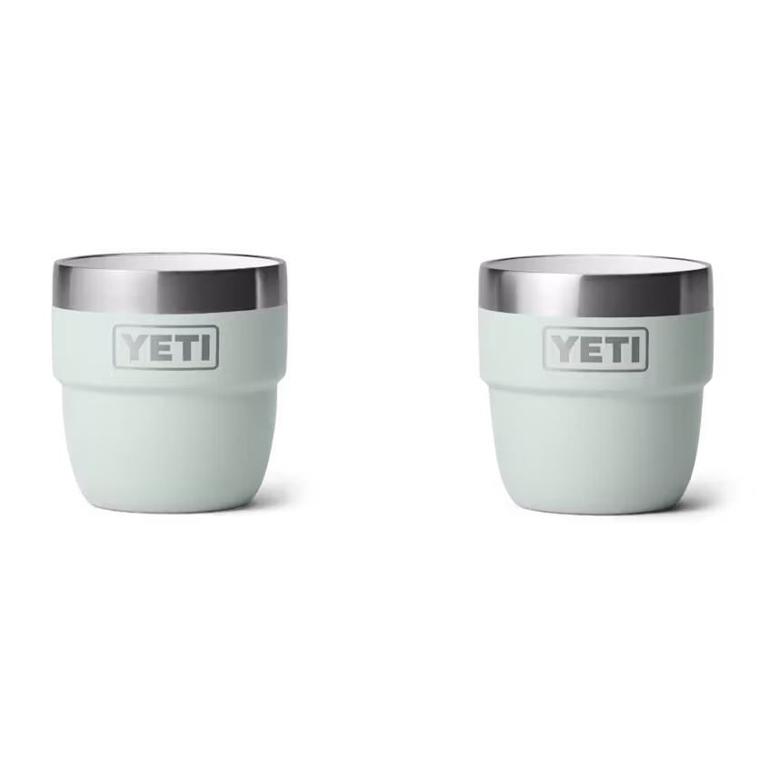 Deux RAMBLER 4 OZ CUPs vert pâle sont placés côte à côte sur un fond blanc. Chaque gobelet affiche le logo YETI sur le devant et possède un bord en acier inoxydable. Livré en pack de 2.