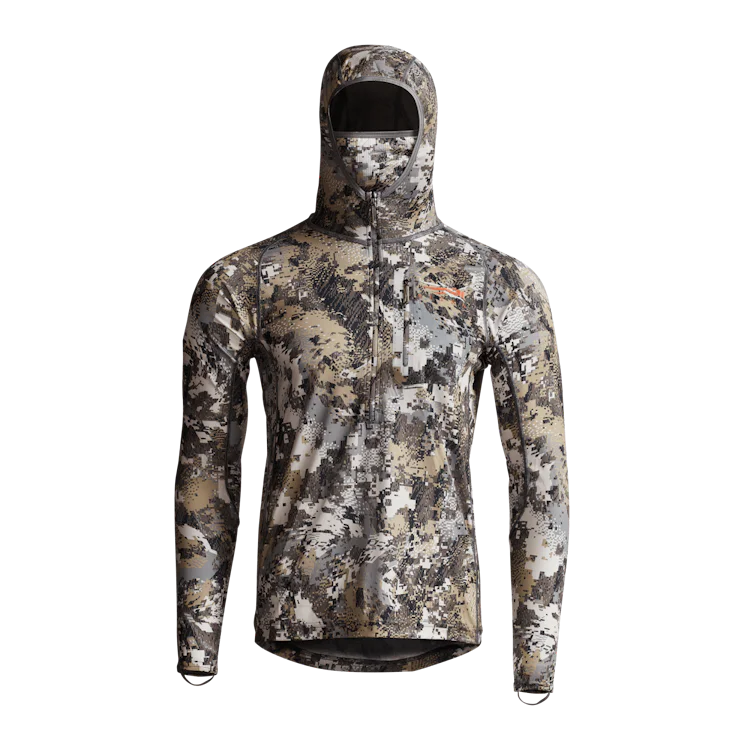 Veste à capuche à manches longues et motif camouflage conçue pour les activités de plein air, avec fermeture éclair sur le devant et logo sur la poitrine. Le motif camouflage intègre différentes nuances de beige, de marron et de gris pour une dissimulation efficace.