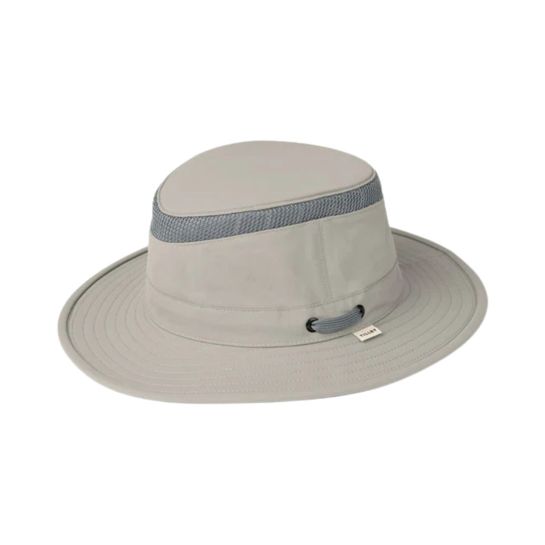 Le chapeau AIRFLO MEDIUM BRIM LTM5 est un chapeau Tilley gris clair doté d'une bande de maille respirante autour de la couronne et d'une mentonnière en cordon gris.