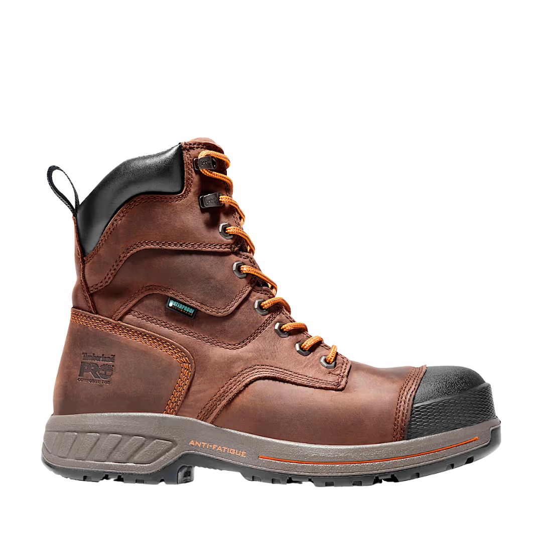 Une botte de travail en cuir marron avec des lacets orange et noirs, un col de cheville noir rembourré, un bout renforcé et une semelle épaisse grise marquée « Anti-Fatigue ». Le logo Timberland PRO est embossé sur le côté.
