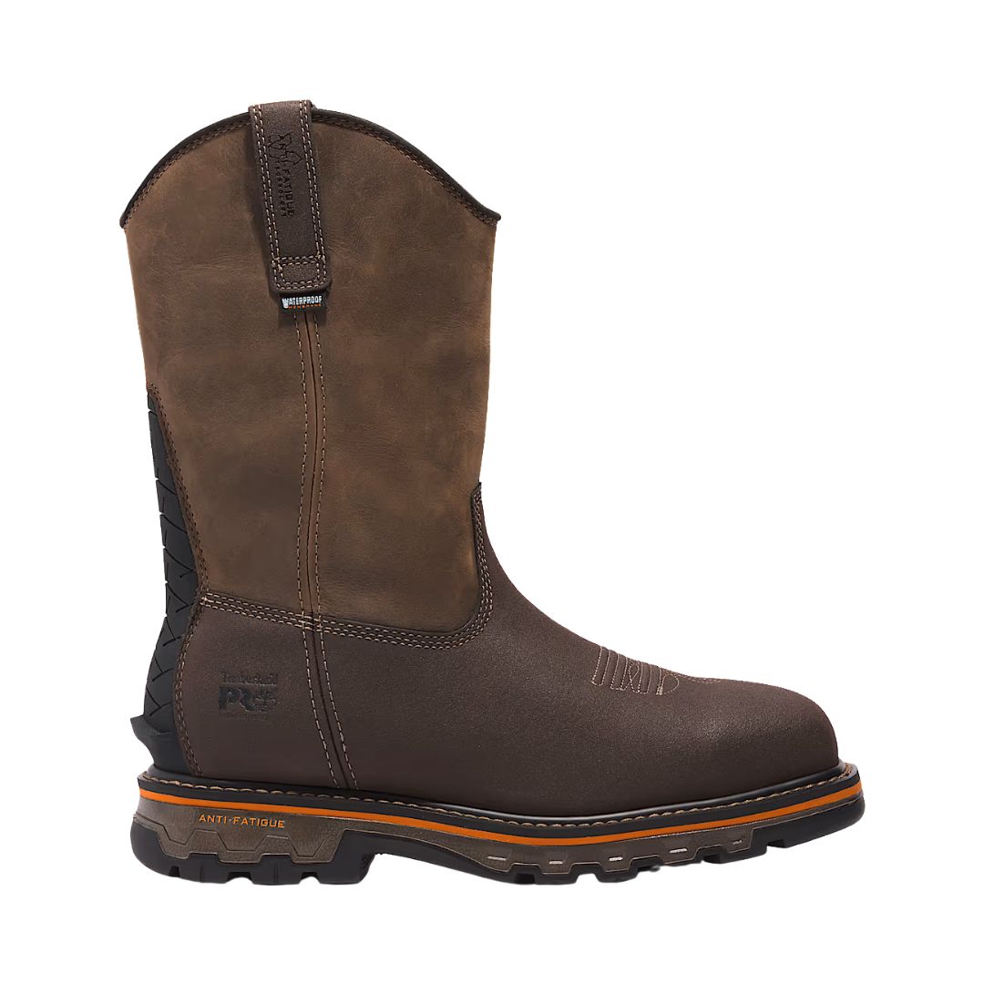 Une botte de travail en cuir marron simple avec une tige haute, une semelle crantée noire et des accents orange, avec des coutures renforcées et une sangle de traction sur le dessus.