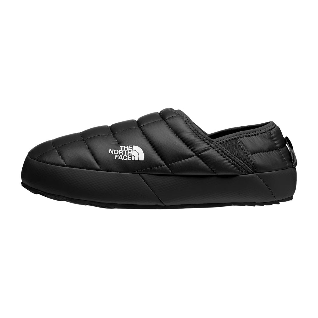 Une chaussure sans lacets noire de la marque FEM, dotée d'un motif matelassé, d'une semelle plate et d'un logo FEM blanc sur le côté.