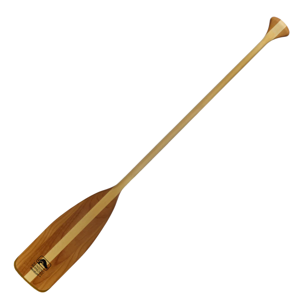 Le TRAVELER est une pagaie de canoë en bois dotée d'un manche long et léger et d'une pale large et plate, ornée d'une bande centrale foncée et d'un petit logo près de la base. Le produit est présenté sur un fond blanc uni.