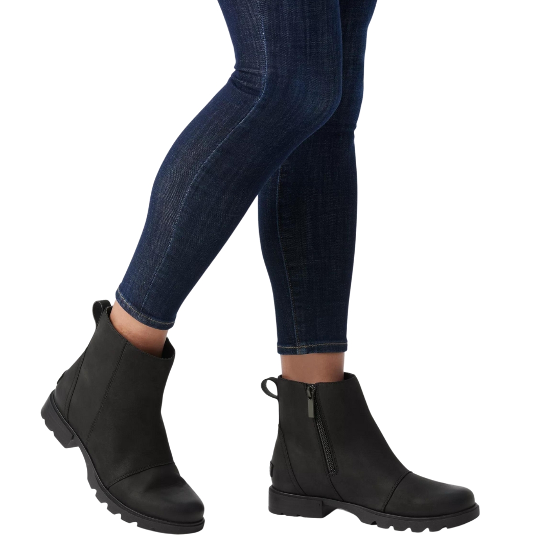 BOTTE D'HIVER IMPERMÉABLE SOREL EMELIE III ZIP POUR FEMME COULEUR 010-BLACK/BLACK VUE DE LES BOTTES NOIRE PORTÉES PAR UNE FEMME VUE DES GENOUX AU PIEDS DE PROFIL DROIT