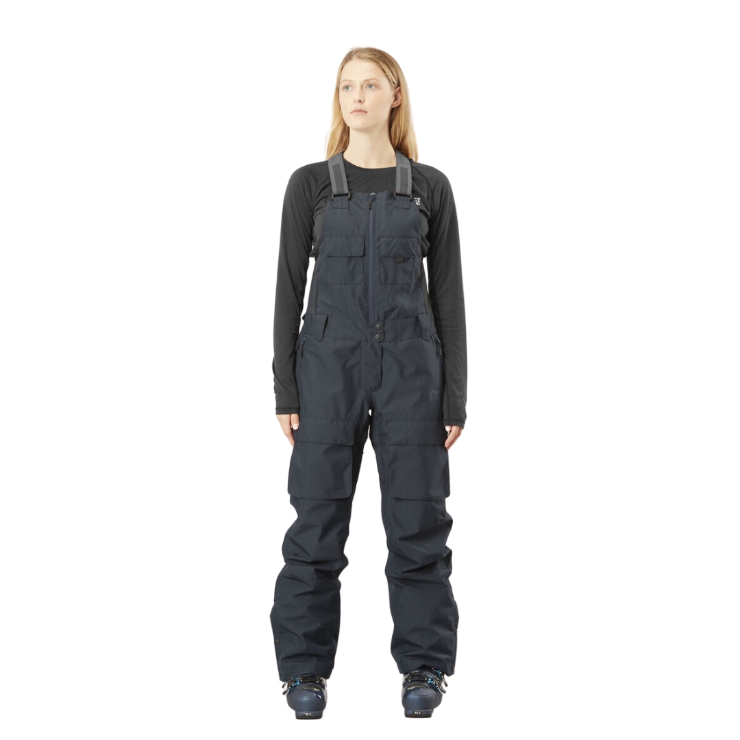 SALOPETTE DE SKI PICTURE BRITA POUR FEMME COULEUR DARK BLUE VUE DE LA SALOPETTE BLEUE MARINE ET NOIRE PORTÉE PAR UNE FEMME VUE DE LA TÊTE AUX PIEDS DE FACE