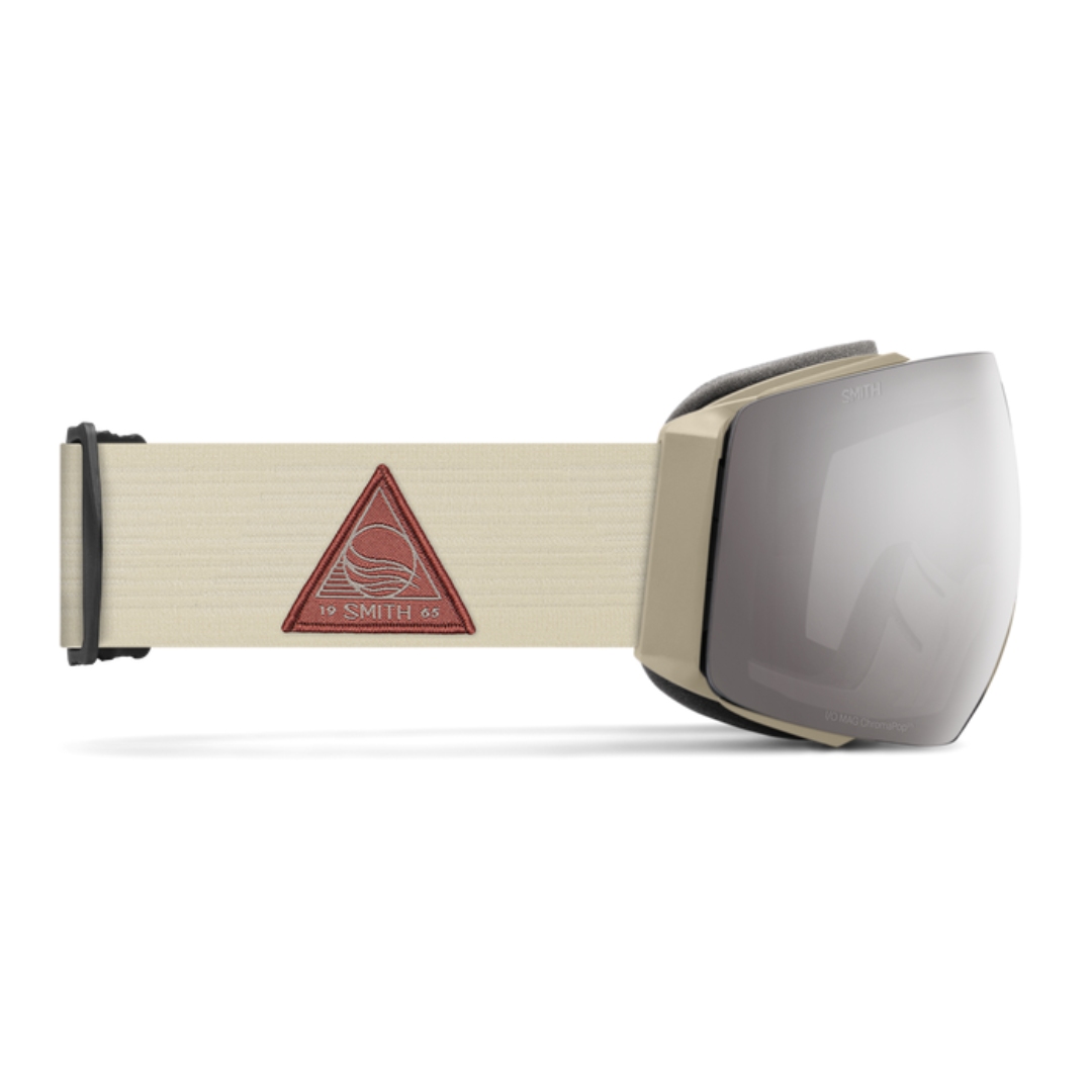 LUNETTE DE SKI ALPIN SMITH OPTICS I/O MAG POUR ADULTE couleur BONE FLOW/CHROMAPOP SUN PLATINUM MIRROR VUE DE LA LUNETTE AVEC ÉLASTIQUE BLANC CRÈME LETTRÉ ROUGE BRIQUE ET LENTILLE PLATINE DE PROFIL DROIT