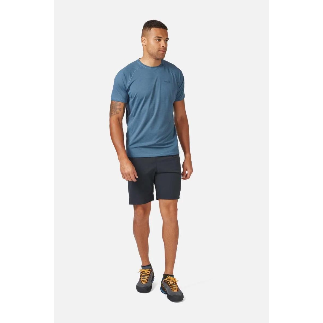 CHANDAIL D'ENTRAINEMENT À MANCHES COURTES RAB SONIC POUR HOMME COULEUR ORION BLUE PORTÉ PAR UN HOMME VU DE LA TÊTE AUX PIEDS DE FACE AVEC LE CHANDAIL BLEU QUI TOMBE À LA MI-HANCHE
